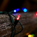Close-up of colorful string lights wrapped around a wooden log, creating a cozy and festive atmosphere.
